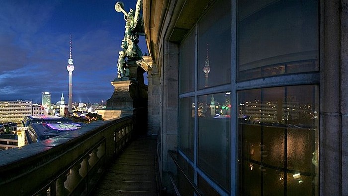 Abendliche Stadtansicht mit Fernsehturm und Statue