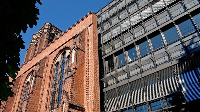 Altes Backsteingebäude neben modernem Glasbau