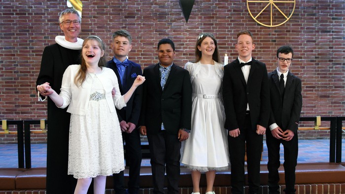 En gruppe af syv personer poserer sammen i en kirke.