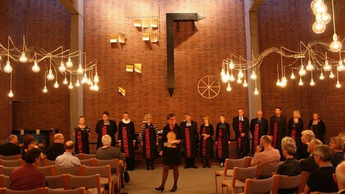 En kor sang i kirke med lys og publikum