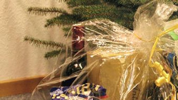 En julegavekasse med chokolade, appelsiner og nøtter.