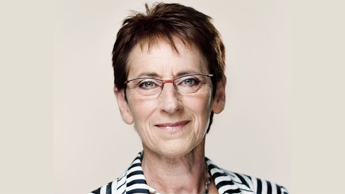 En kvinde med kort hår og briller.