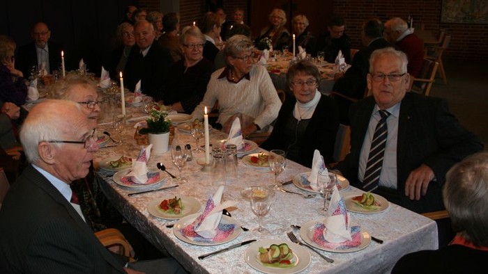 En gruppe mennesker sidder ved et bord og spiser.