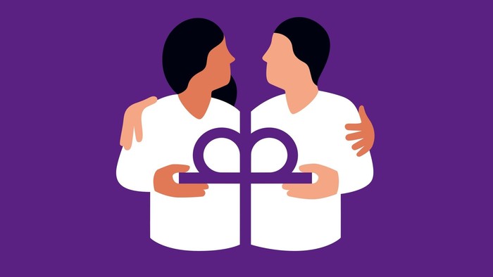 Zwei Personen halten ein Symbol der Vielfalt in den Händen