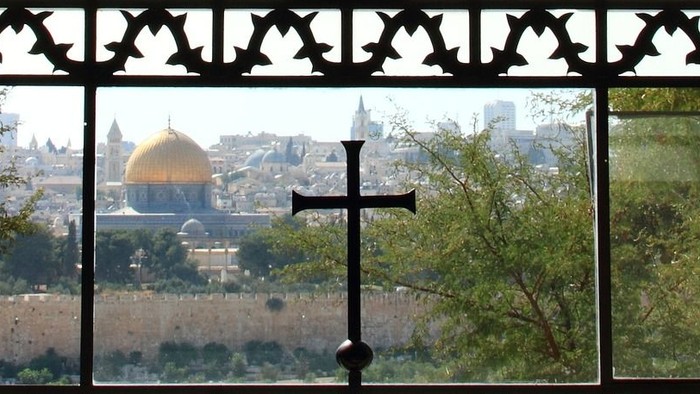 Ein Kirchenfenster mit Kreuz und Stadtansicht