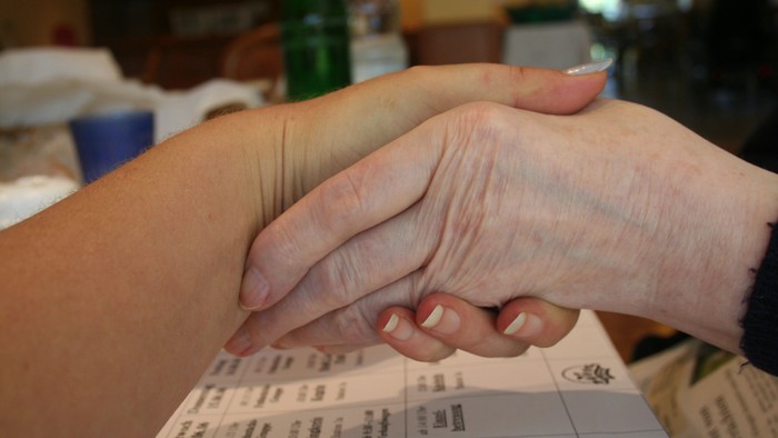 Zwei Personen halten sich an den Händen über einem Kalender