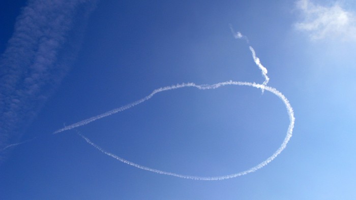 Ein Herz aus Kondensstreifen am blauen Himmel