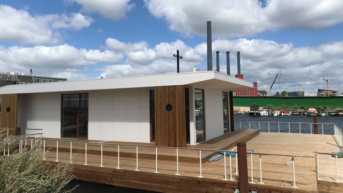 En moderne hyttebåds med træ og metal på vandet