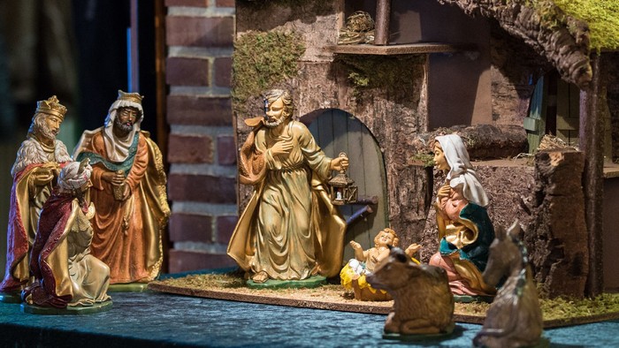 En julekreds med several figurer foran en lille hytte.