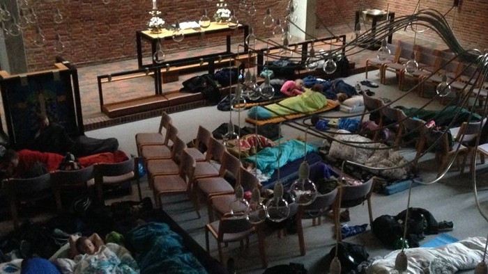 En stor hall med mange sovsæder og folk, der sover.