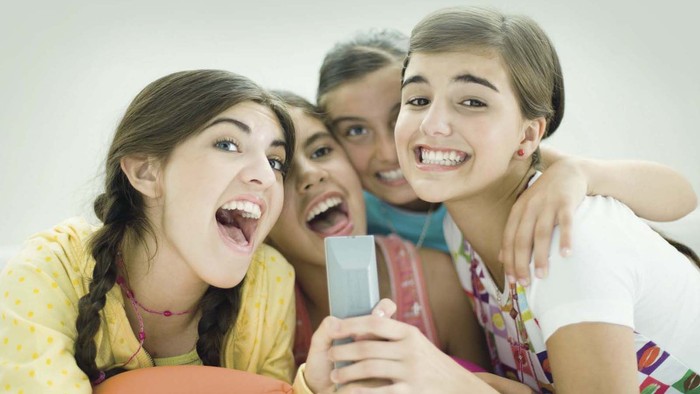 Fire unge piger tager selfie sammen og ser glade ud