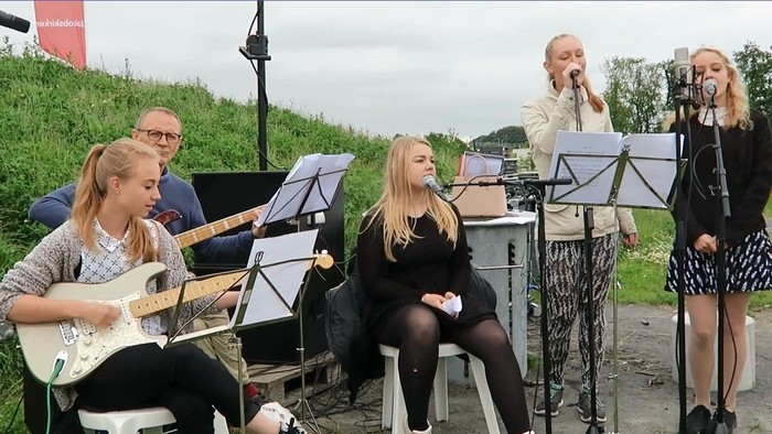 En gruppe af musiker og sanger på en ude scene
