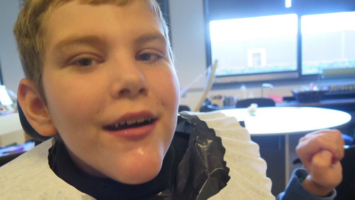 En dreng med en papirhat på hovedet.