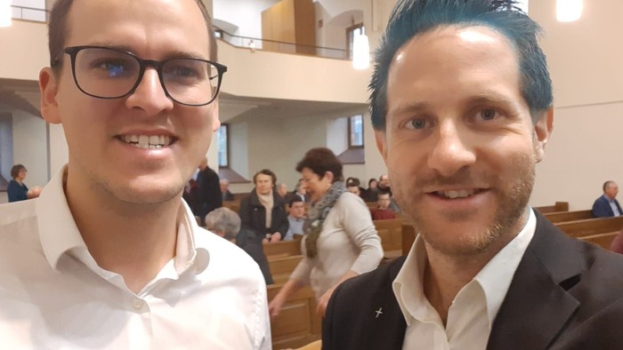 Zwei Männer posieren in einer Kirche.