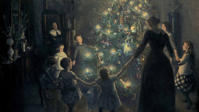 En julestue med familie om en belyset juletree