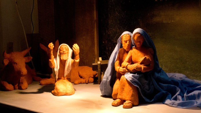 Eine Krippe mit Figuren, darunter Maria, Josef und das Jesuskind, in einer Nische.