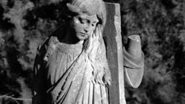 Die Statue einer Frau mit einem Schild.