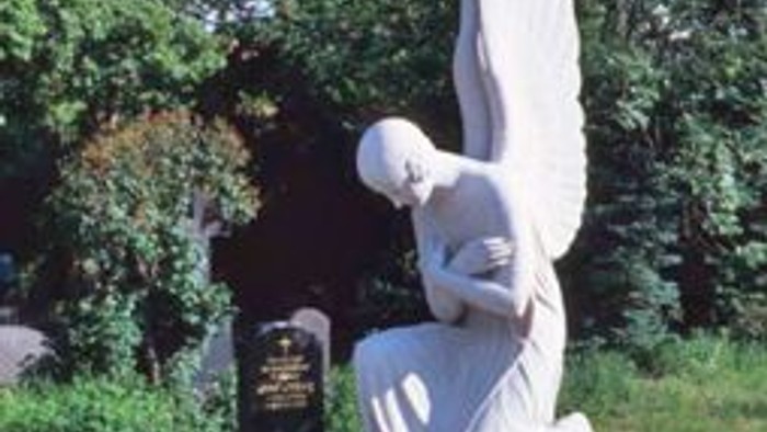 Ein Engel-Denkmal auf einem Sockel in einem Park