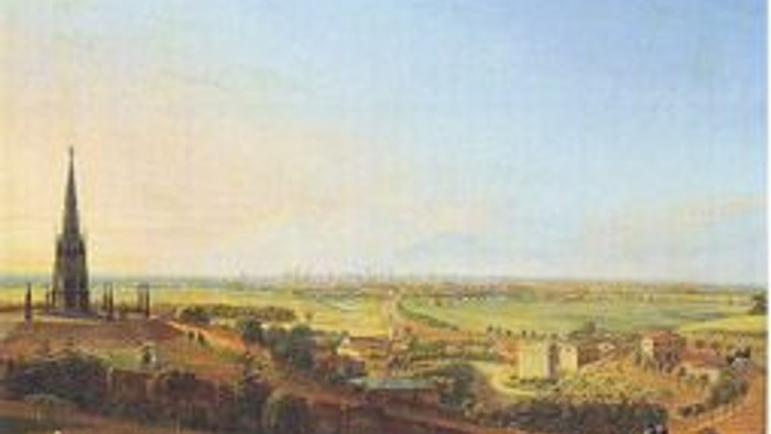 Das Bild zeigt eine weite Landschaft mit einem hohen Turm und vielen Gebäuden.