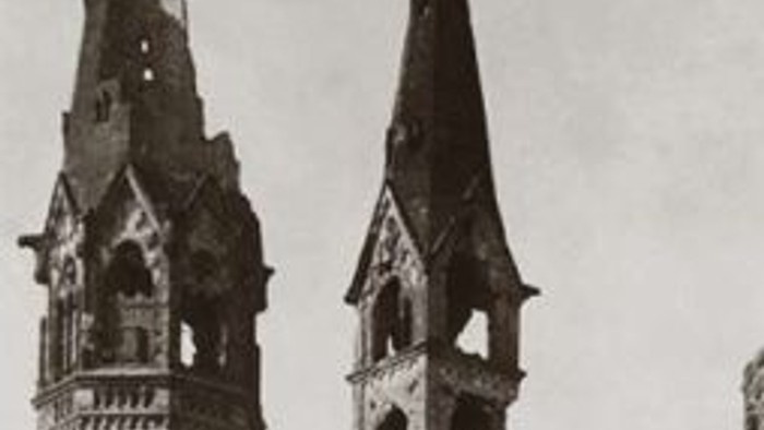 Das Bild zeigt zwei gotische Kirchtürme mit spitzen Dächern und aufwendigen architektonischen Details.