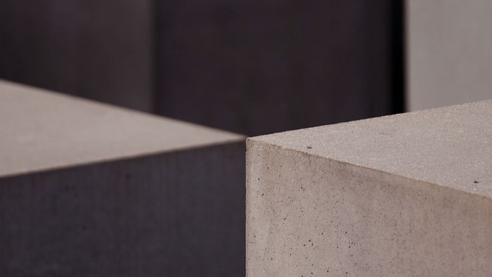 Zwei graue Betonblöcke vor dunklem Hintergrund