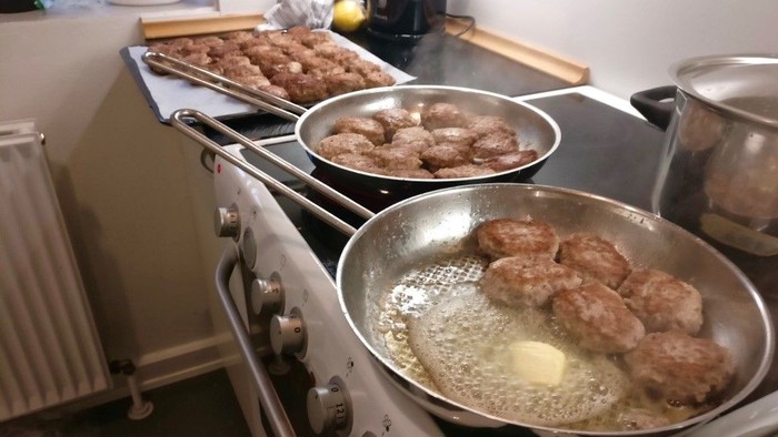 En husholdning med tre pander på en køkkenovn, hvor et par pander frydes i panderpander.