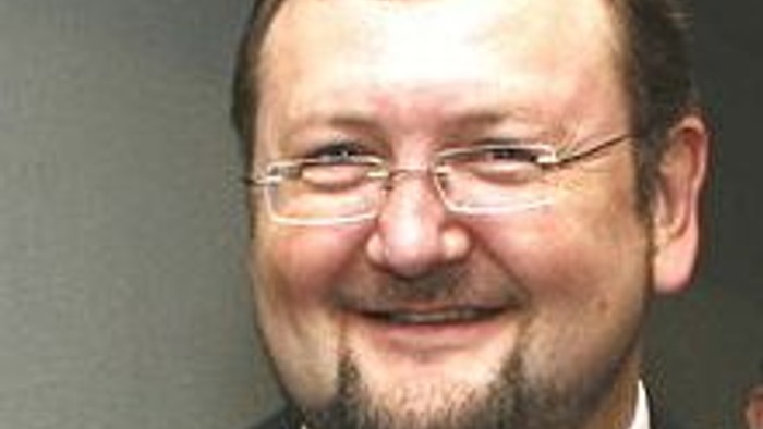 Ein Mann mit Brille und Kippah lächelt.