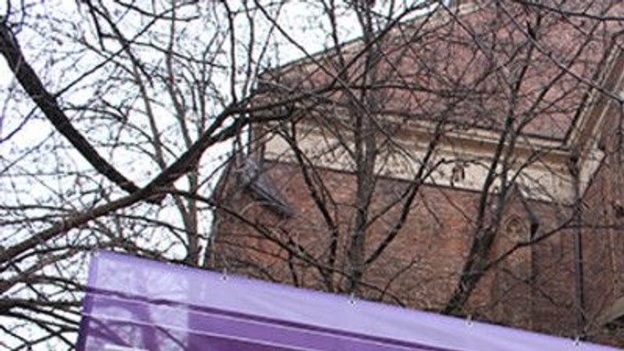 Buntes Banner vor alter Kirche