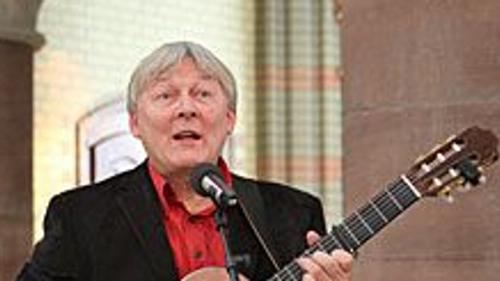 Mann spielt Gitarre auf Bühne