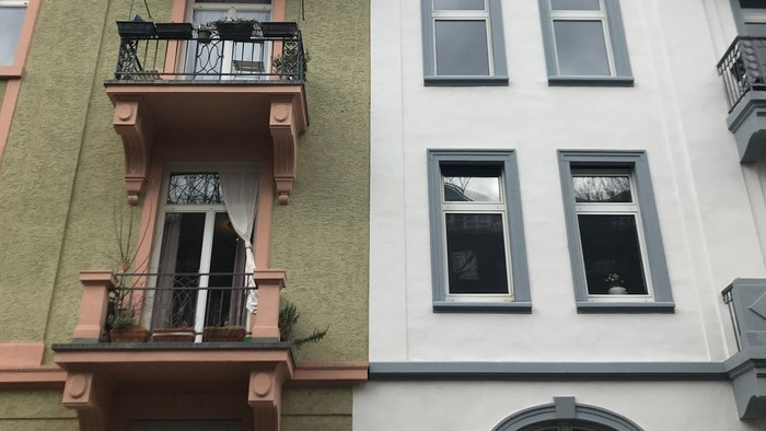 Zwei Gebäude mit Balkonen und vielen Fenstern.