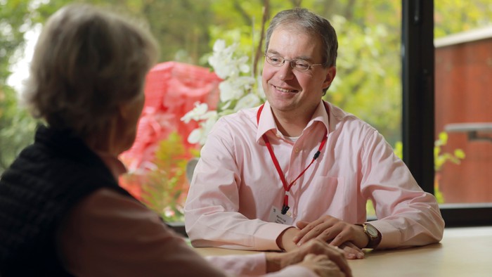 Ein Mann und eine Frau sitzen an einem Tisch und unterhalten sich.
