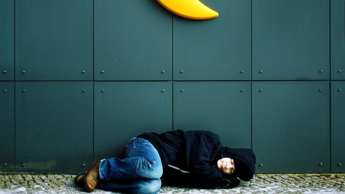 Person sitzt vor grünen Wand mit gelbem Mond.
