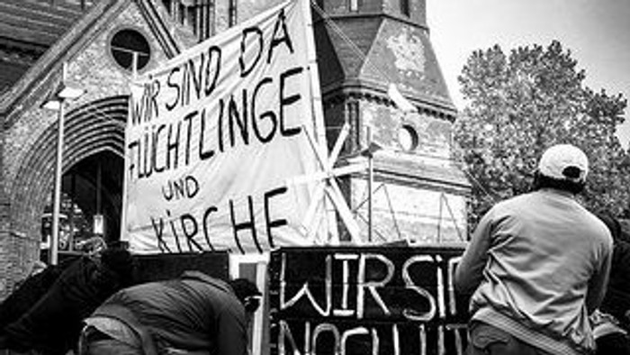 Protestierende mit Schildern und Plakaten vor historischem Gebäude