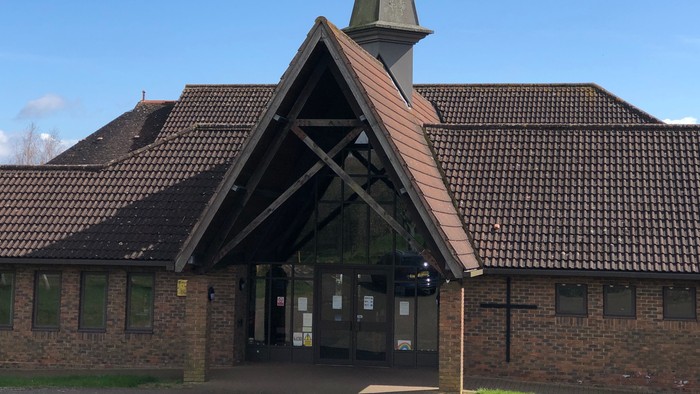 Church building with tall steeple and brick exterior