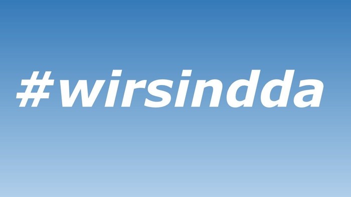 Ein blauer Hintergrund mit dem Hashtag „#wirsindda“ in weißer Schrift.