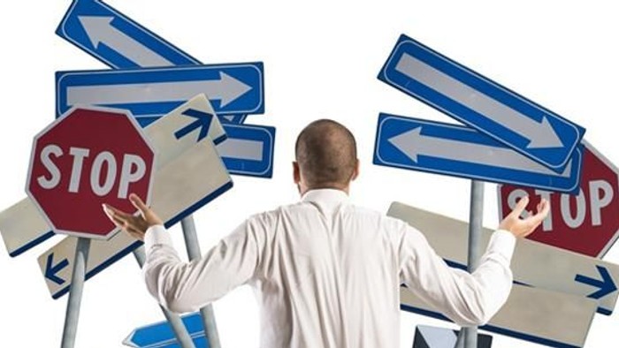 Mann steht zwischen verkehrszeichen