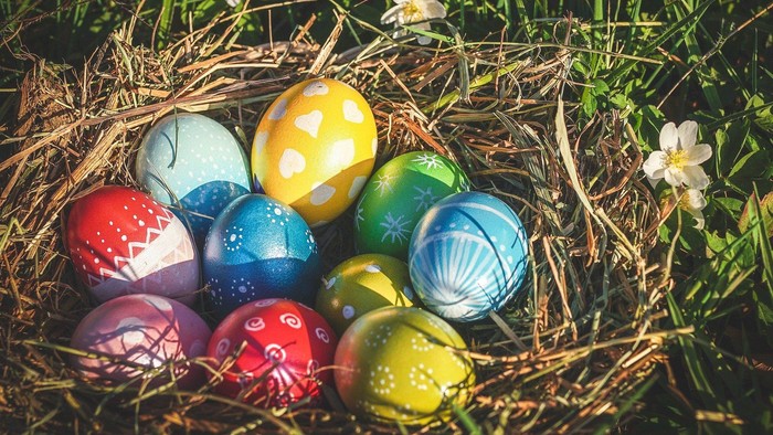 Bunte Ostereier in einem Korb im Gras