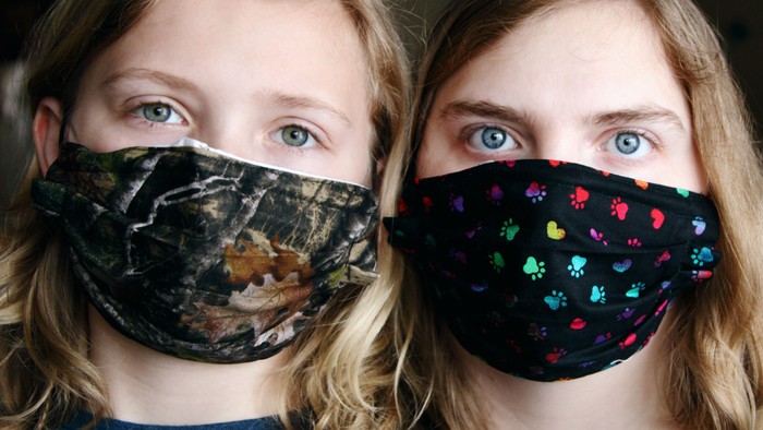 Zwei Frauen mit Mund-Nasen-Schutz posieren für Foto