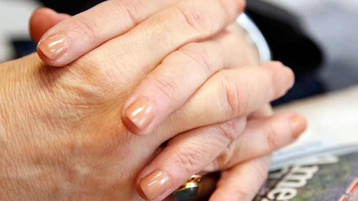 To hands holder hinanden, en ring ses på en af fingrene