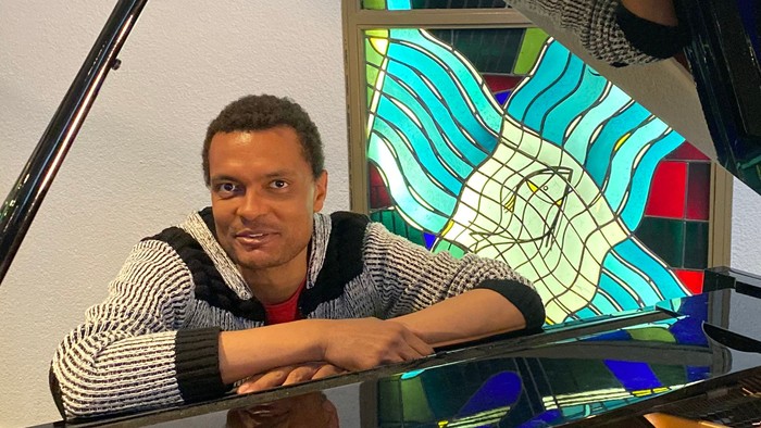 Mann sitzt im Inneren eines Flügels und spielt Klavier