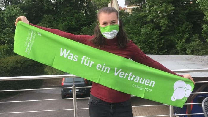 Frau hält grünes Banner mit Aufdruck "Was für ein Vertrauen"