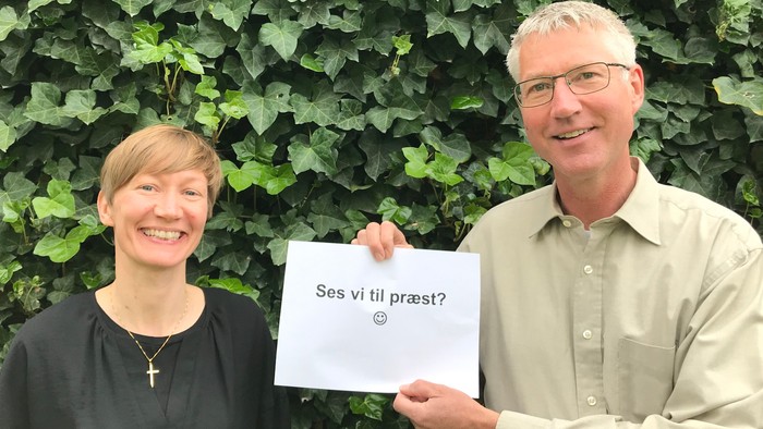 En mand og en kvinde holder en papir med spørgsmålet