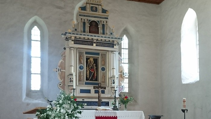In der Kirche steht ein Altar mit Ikonen und Blumen.
