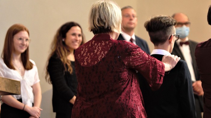 Eine Gruppe von Menschen steht in einem Raum und unterhält sich.