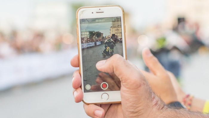 Hand hält Smartphone mit Videoaufnahme von Konzert