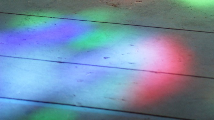 Bunte Lichtreflexe auf Holzboden
