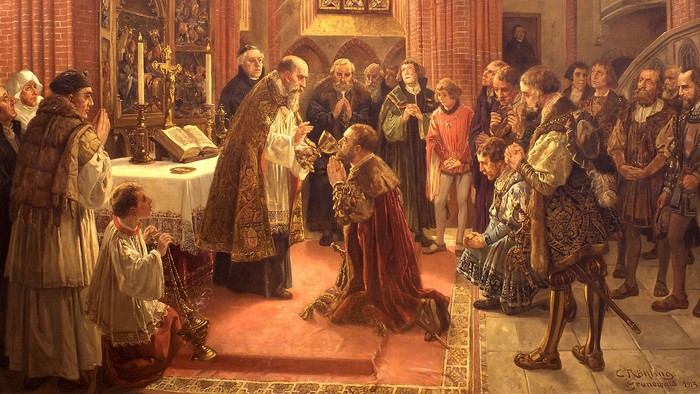 Eine Gruppe von Menschen betet in einer Kirche, ein Priester segnet ein Kind.