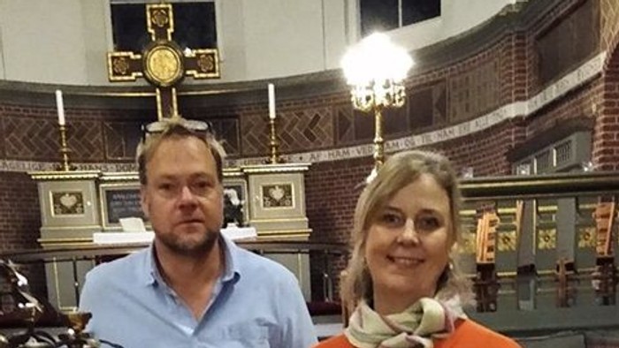 To par står sammen i et historisk lokal med mursten og oldtidsfrier