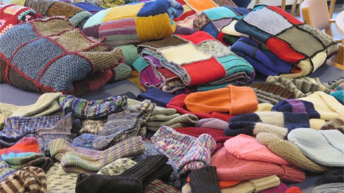 En mangfoldighed af farvede strømper og skærp, stakket på en bord.