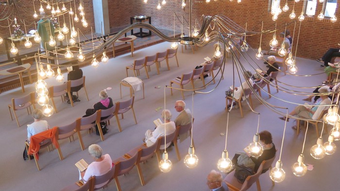 En stor hall med mange belysninger og folk der sidder og læser.